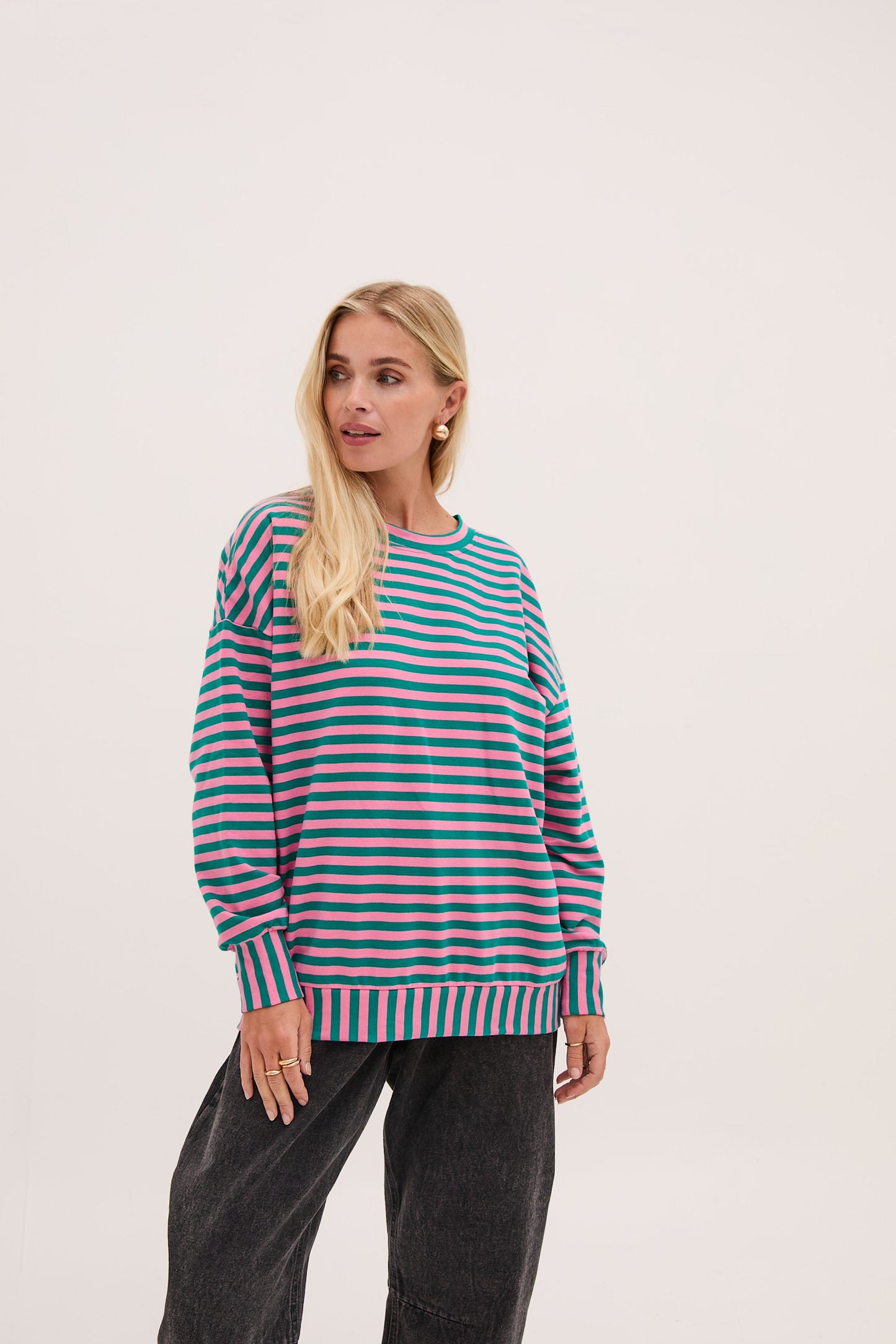 Woman wearing a striped sweater on a light pink background