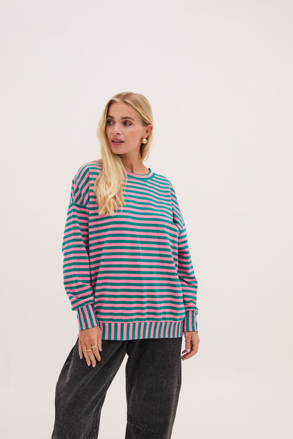 Woman wearing a striped sweater on a light pink background